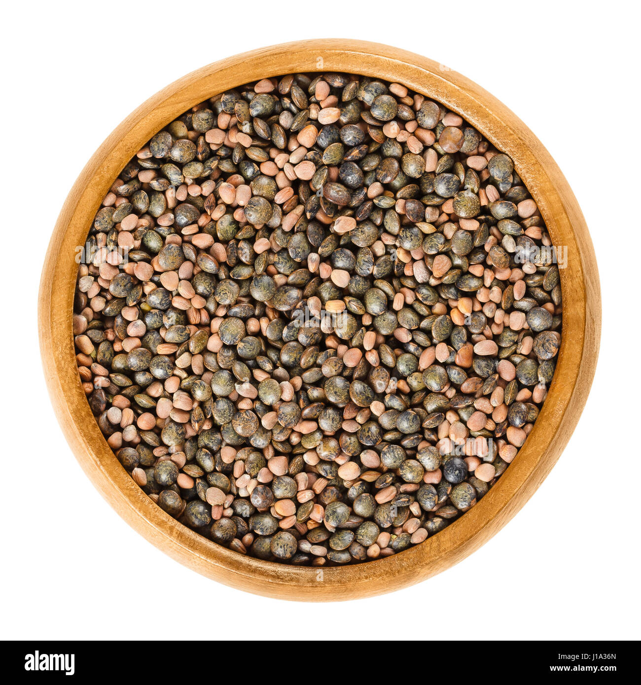 Semi di ramolaccio e verde screziato lenticchie in ciotola di legno. Raphanus sativus e Lens culinaris. Piccante mix di semi per la germinazione. Isolate il cibo macro foto. Foto Stock