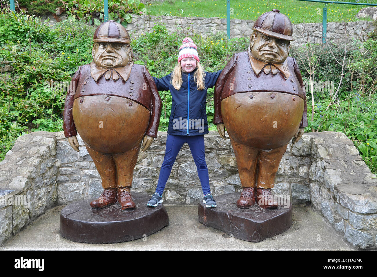 Ragazza tra Tweedledee e Tweedledum statue in Llandudno, Wales, Regno Unito Foto Stock