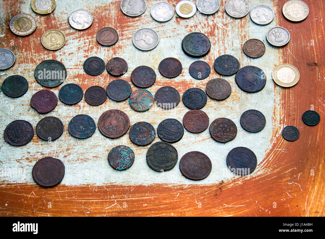 Di vecchie monete su sfondo graffiato. Messa a fuoco selettiva. Foto Stock