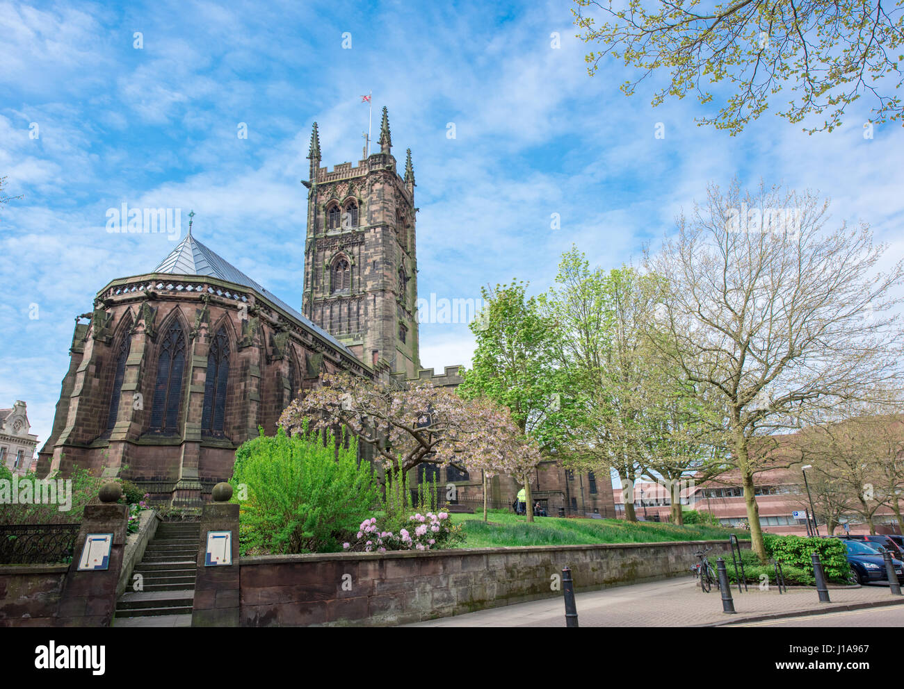 Vista su di una giornata di primavera di San Pietro Chiesa Collegiata di Wolverhampton con il consiglio della città ha uffici in background con il blu del cielo. Foto Stock
