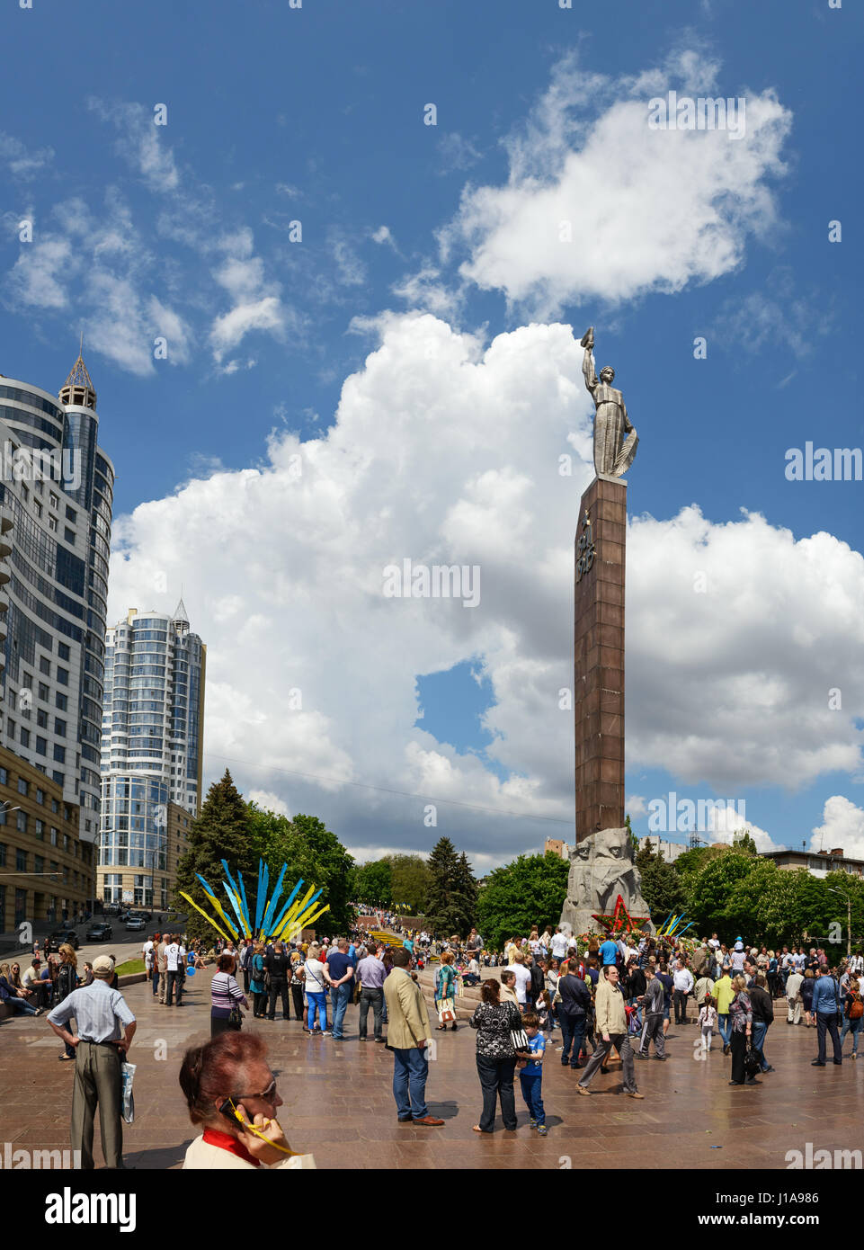 Le persone che sono la posa di fiori sono in prossimità della luce eterna nella parte anteriore del monumento di gloria nella vittoria giorno 09 Maggio in Dnepropetrovsk, Ucraina. Foto Stock