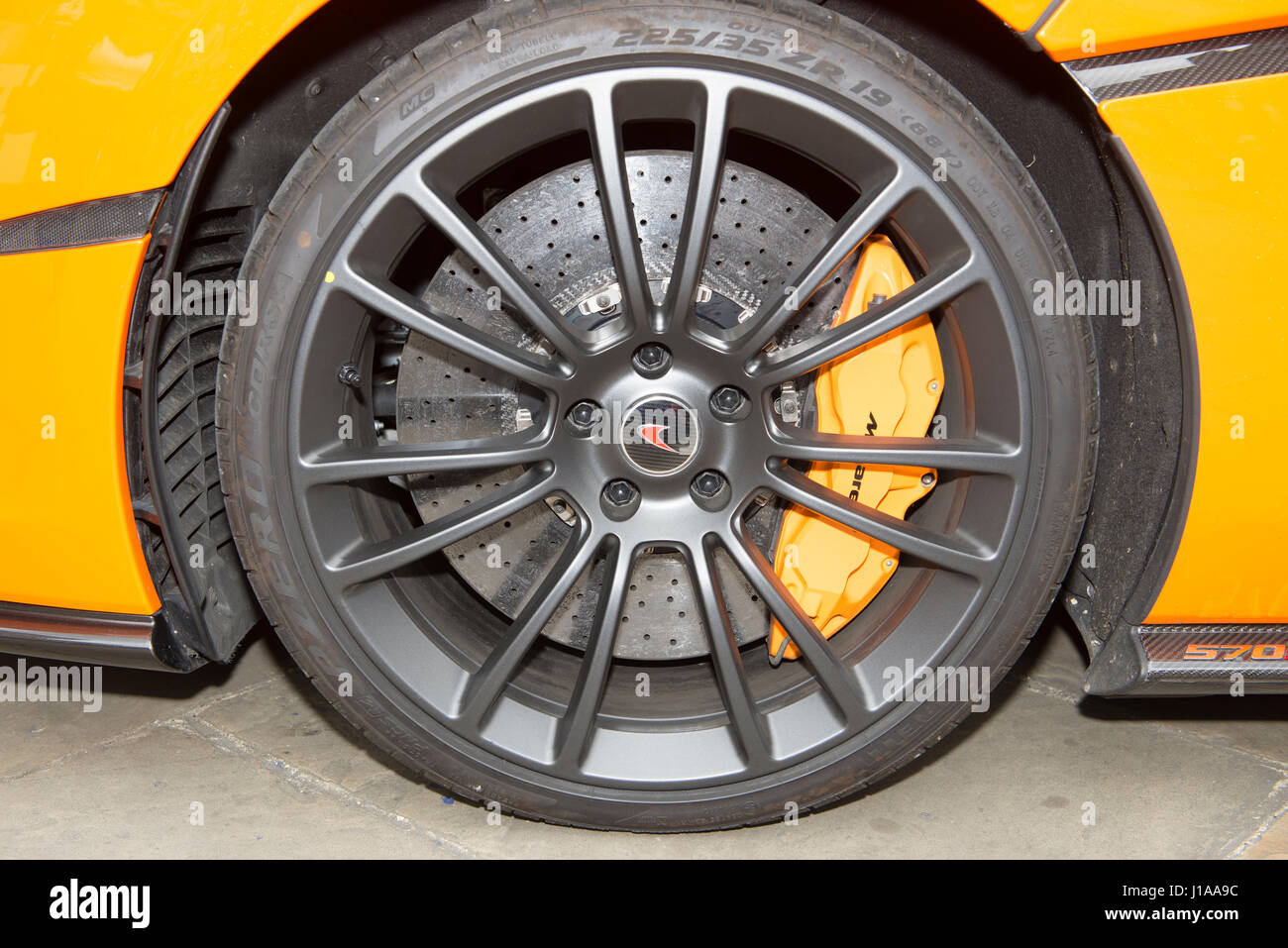 Il cerchio in lega, dischi freno in carbonio ceramico e le pinze di una McLaren 570s sportscar Foto Stock