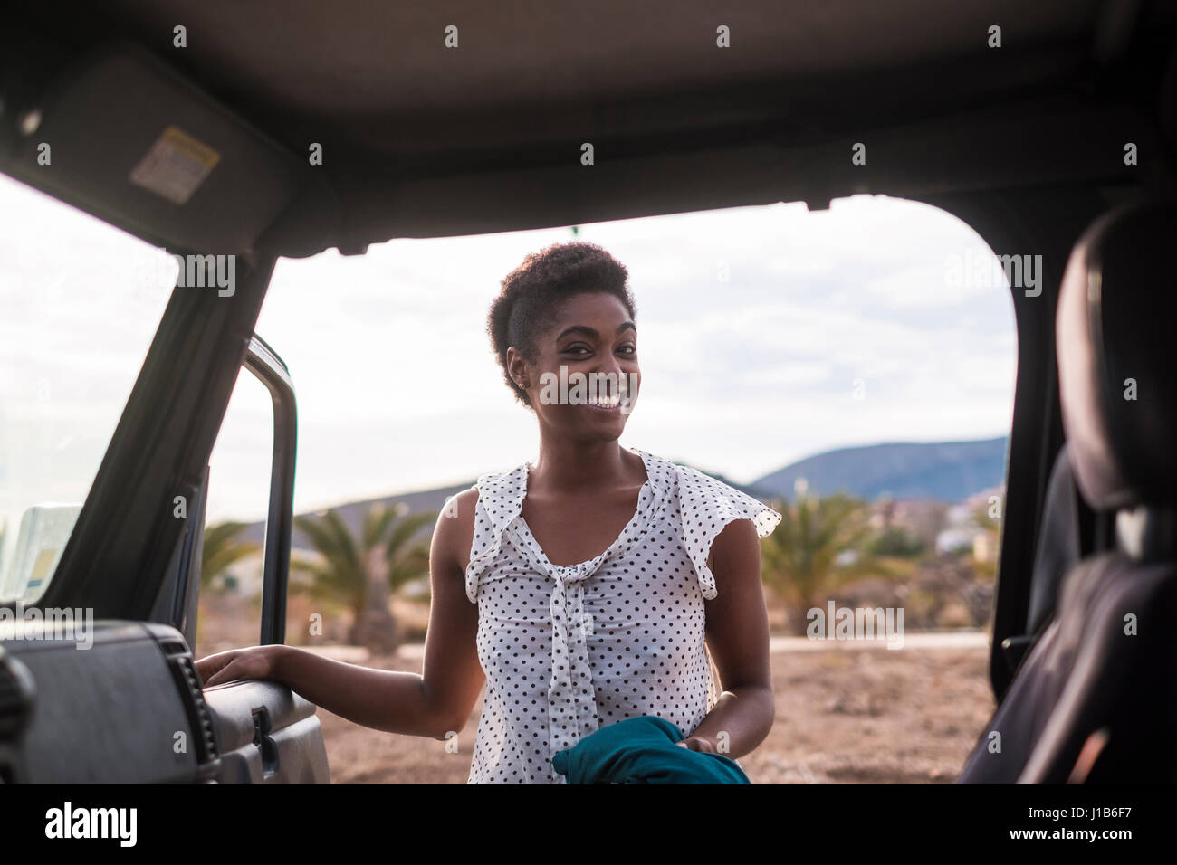 Sorridente americano africano donna apertura porta auto Foto Stock