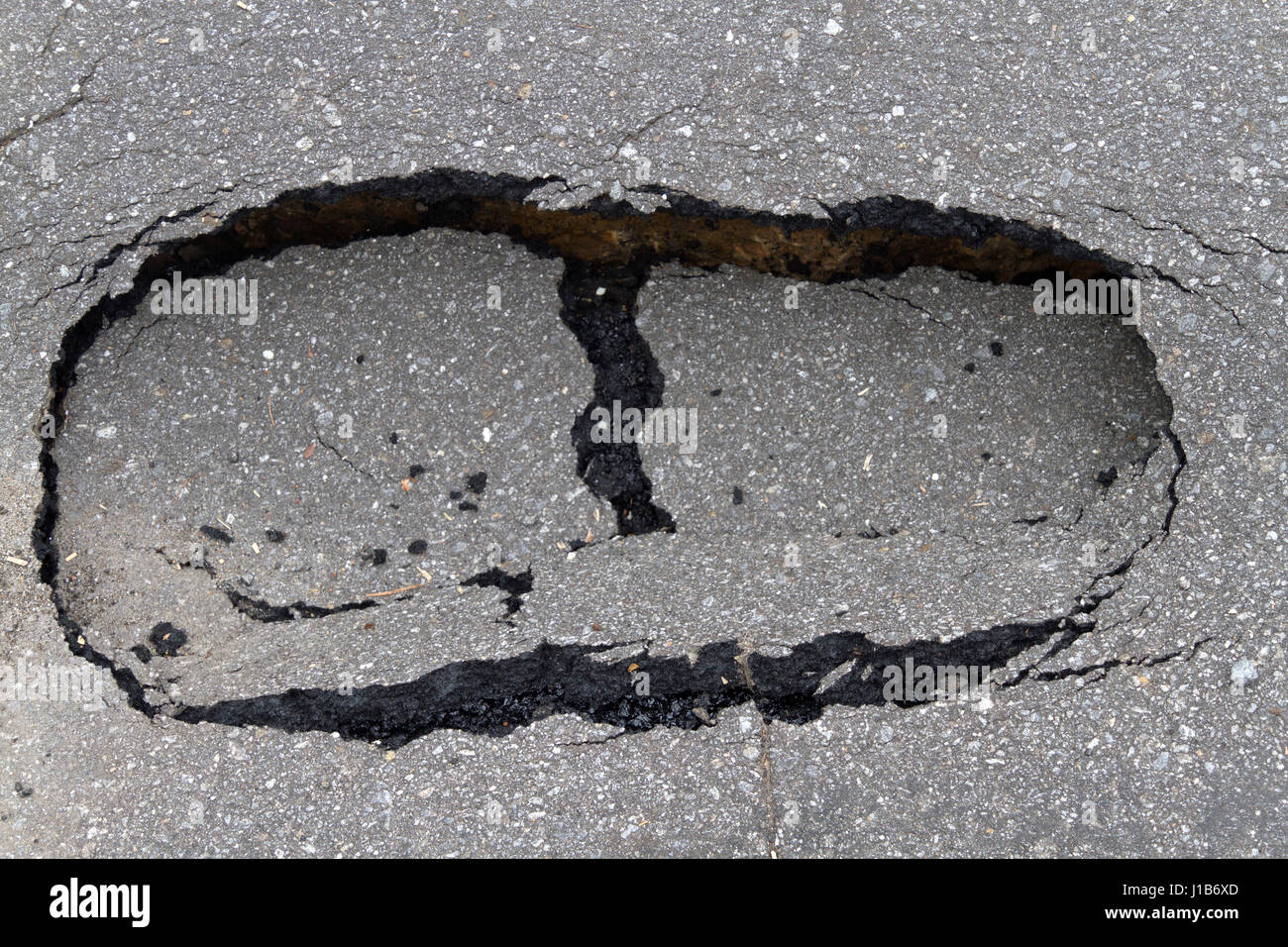 In prossimità di una piccola dolina di asfalto nella strada conformata come un grande ingombro Foto Stock