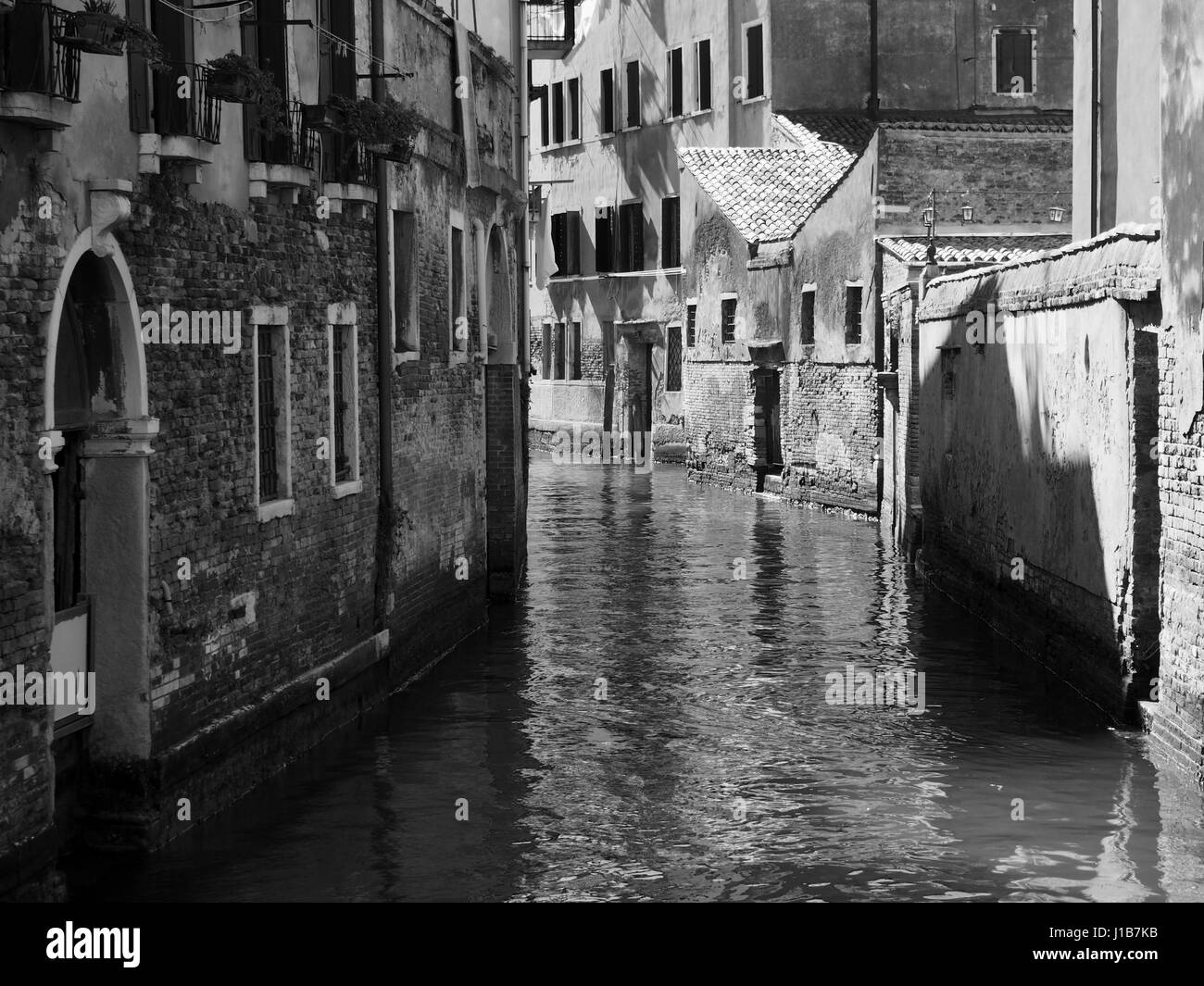 Un canale di Venezia con luce e ombra Foto Stock