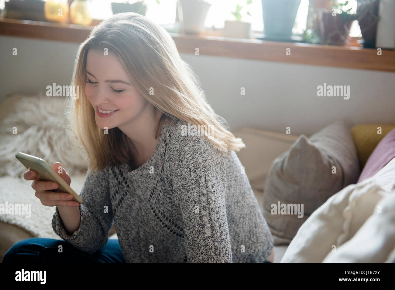 Donna sorridente sms sul cellulare Foto Stock