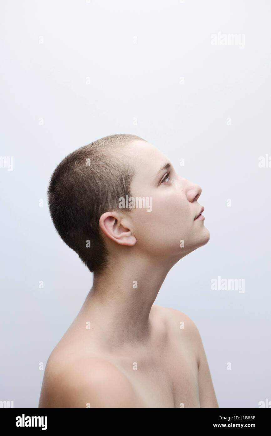 La donna caucasica con radere la testa guardando in alto Foto Stock