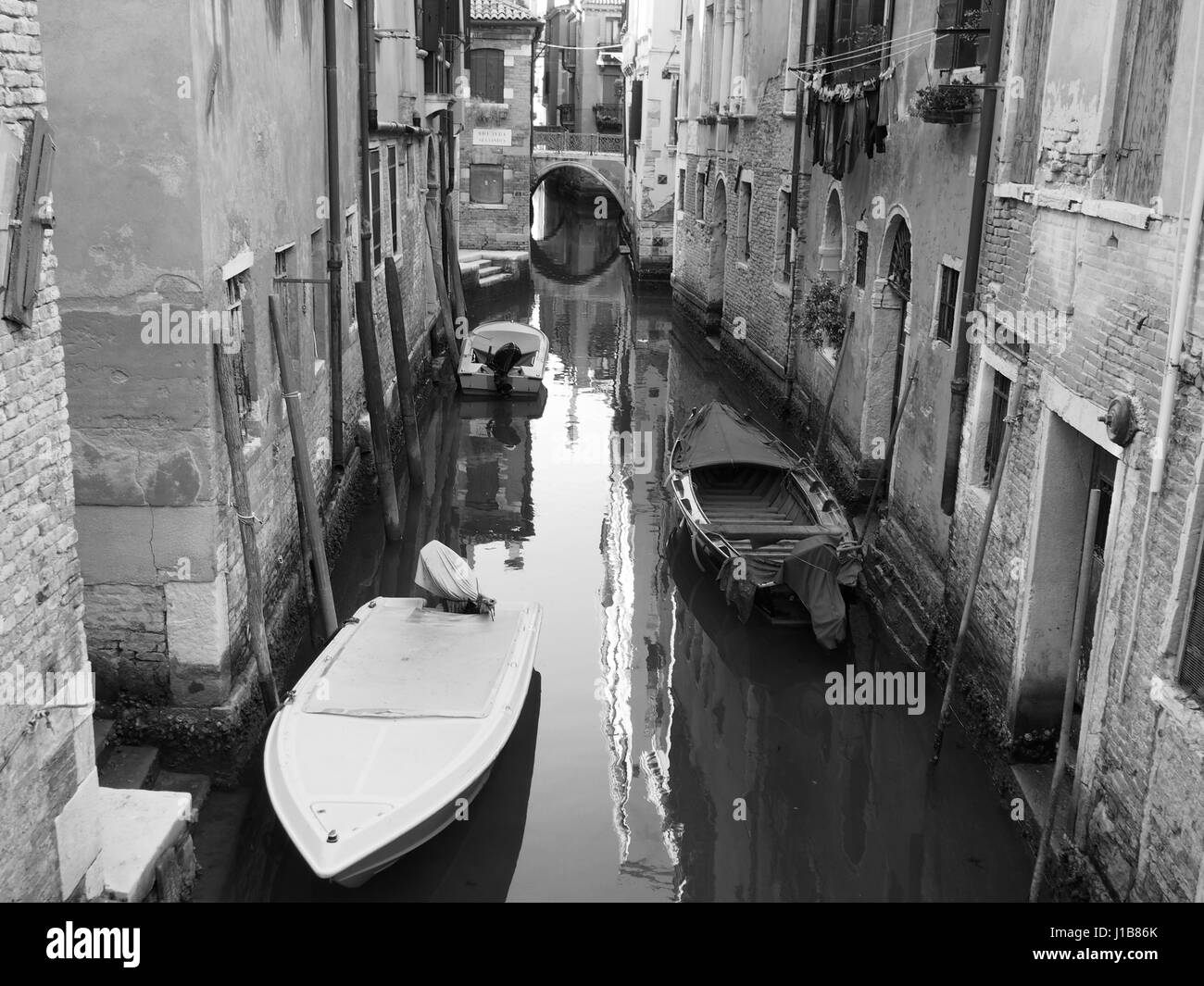 Tranquilla piccola Canal a Venezia con il ponte e barche Foto Stock