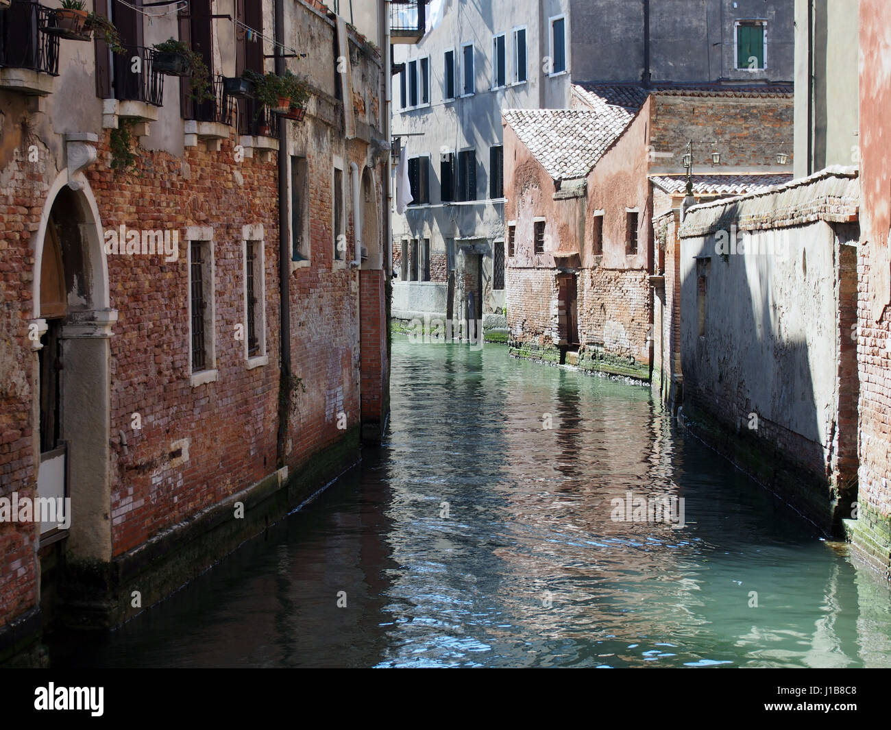 Un canale di Venezia con luce e ombra Foto Stock