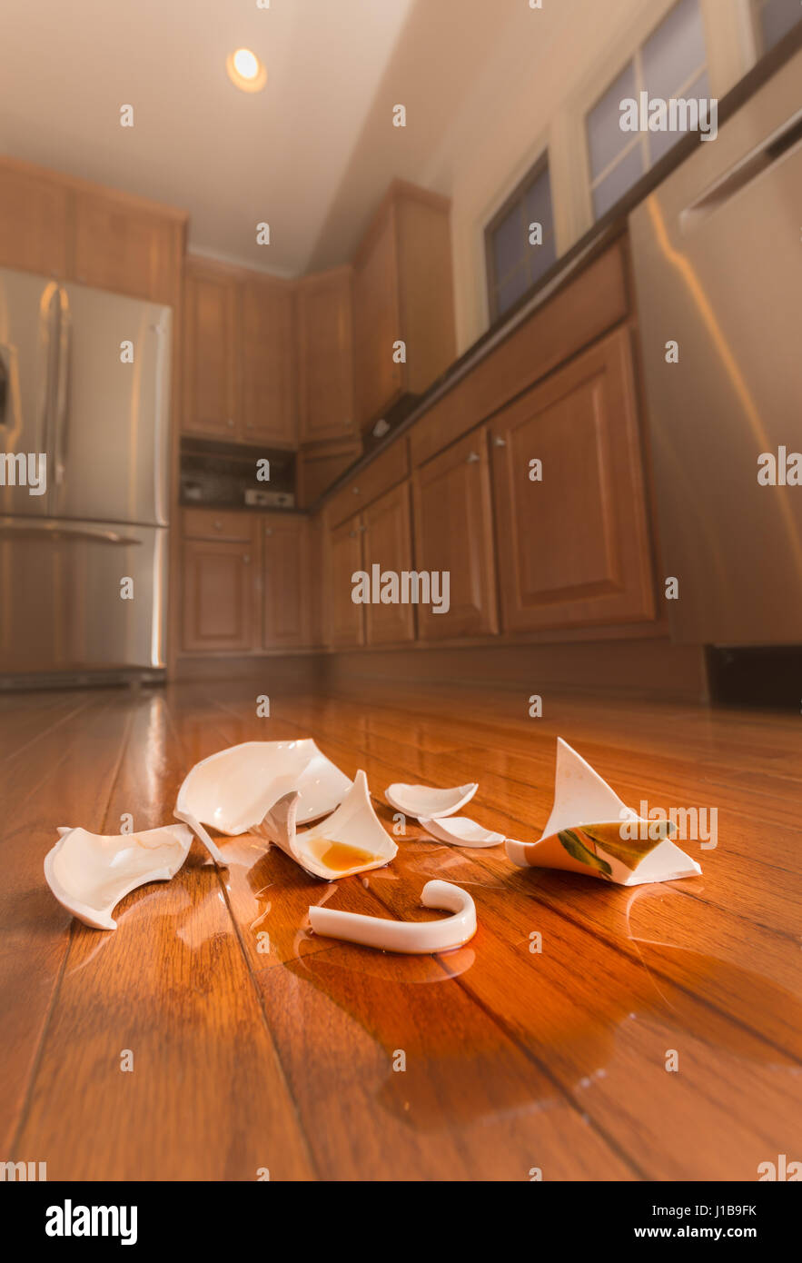 Rotture di tazza di caffè sul pavimento della cucina moderna - la violenza domestica concept Foto Stock