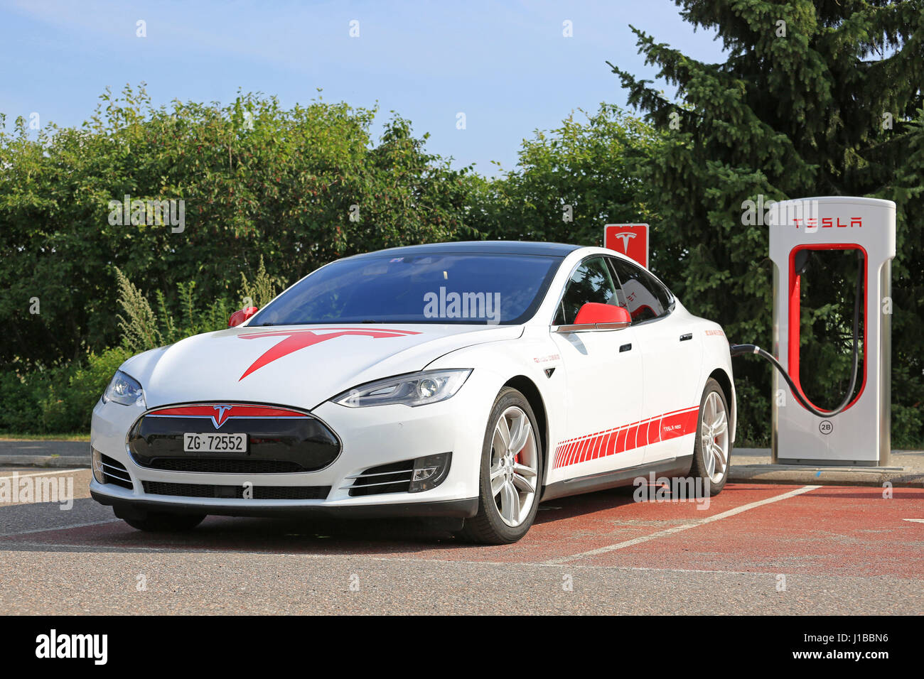 PAIMIO, Finlandia - 24 luglio 2016: il bianco e il rosso unico design signage Tesla Model S carica sulla stazione di sovralimentazione nel sud della Finlandia. In 2016, ther Foto Stock