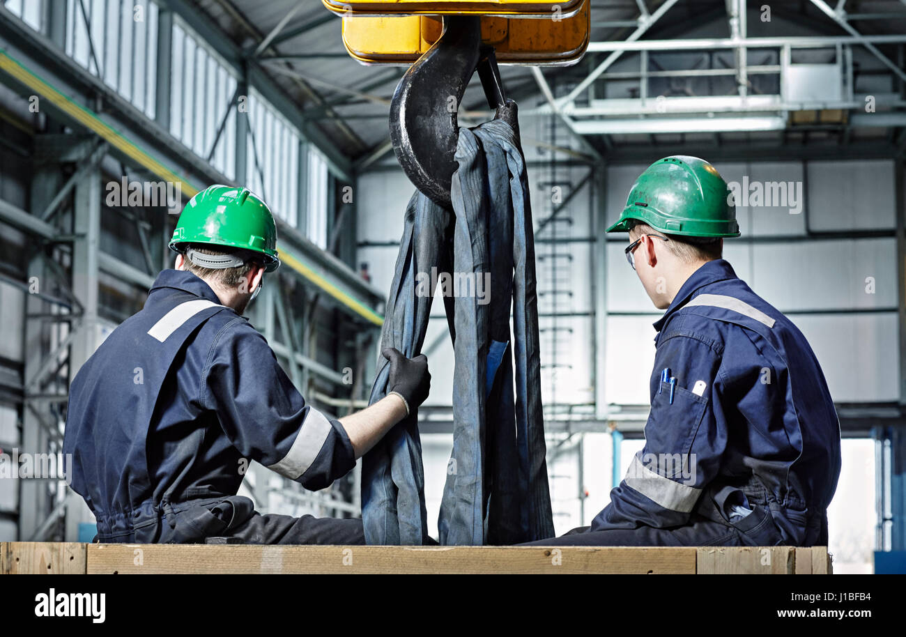 Gli uomini la preparazione di gran parte di macchina per gru di sollevamento. Industria pesante, il sollevamento di carichi pesanti, Ingegneria, occupazione, 'Men sul luogo di lavoro " forza lavoro, Industriale Foto Stock