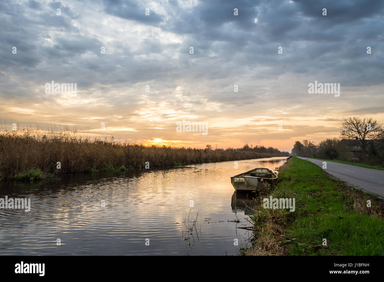 Barca a remi in un canale durante il tramonto Foto Stock