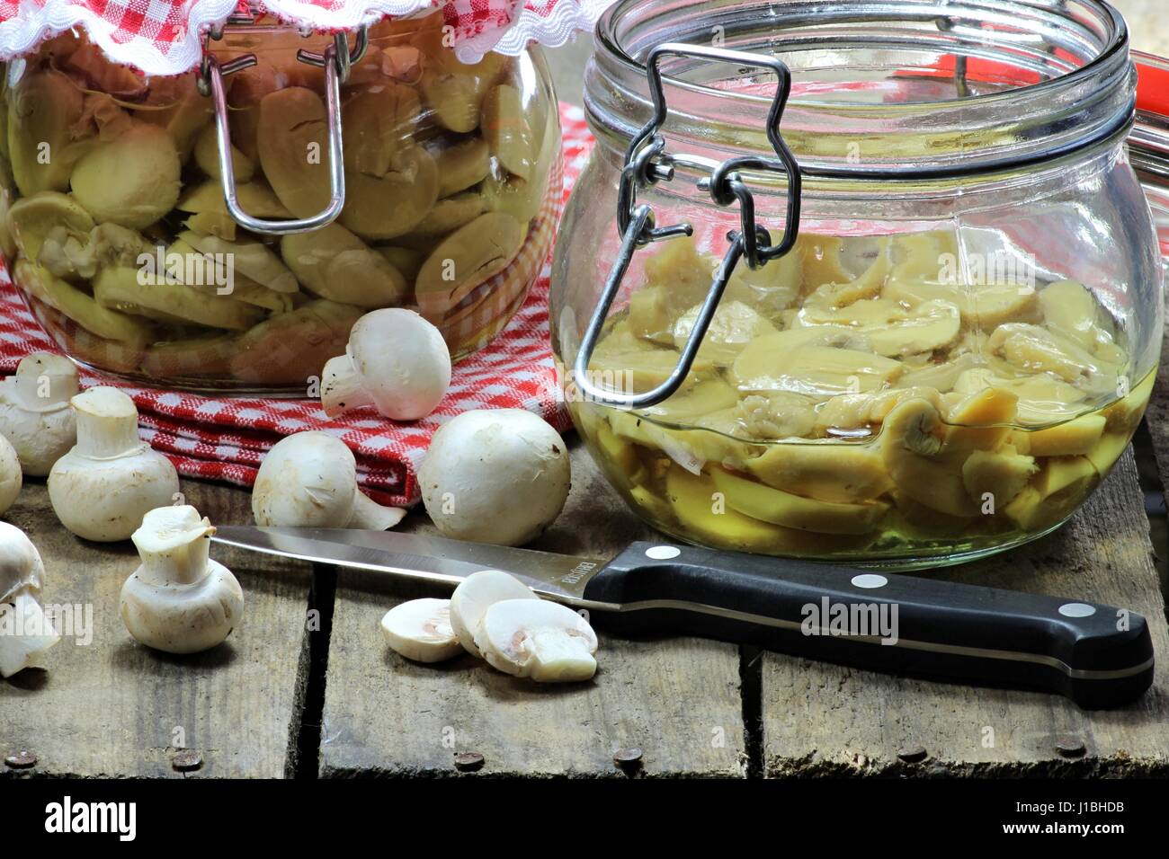 Home conserve di funghi su sfondo di legno Foto Stock