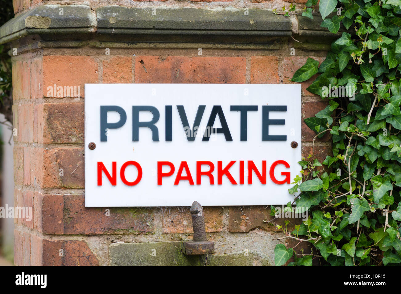 Grande segno dicendo 'privato parcheggio non' su un muro di mattoni Foto Stock