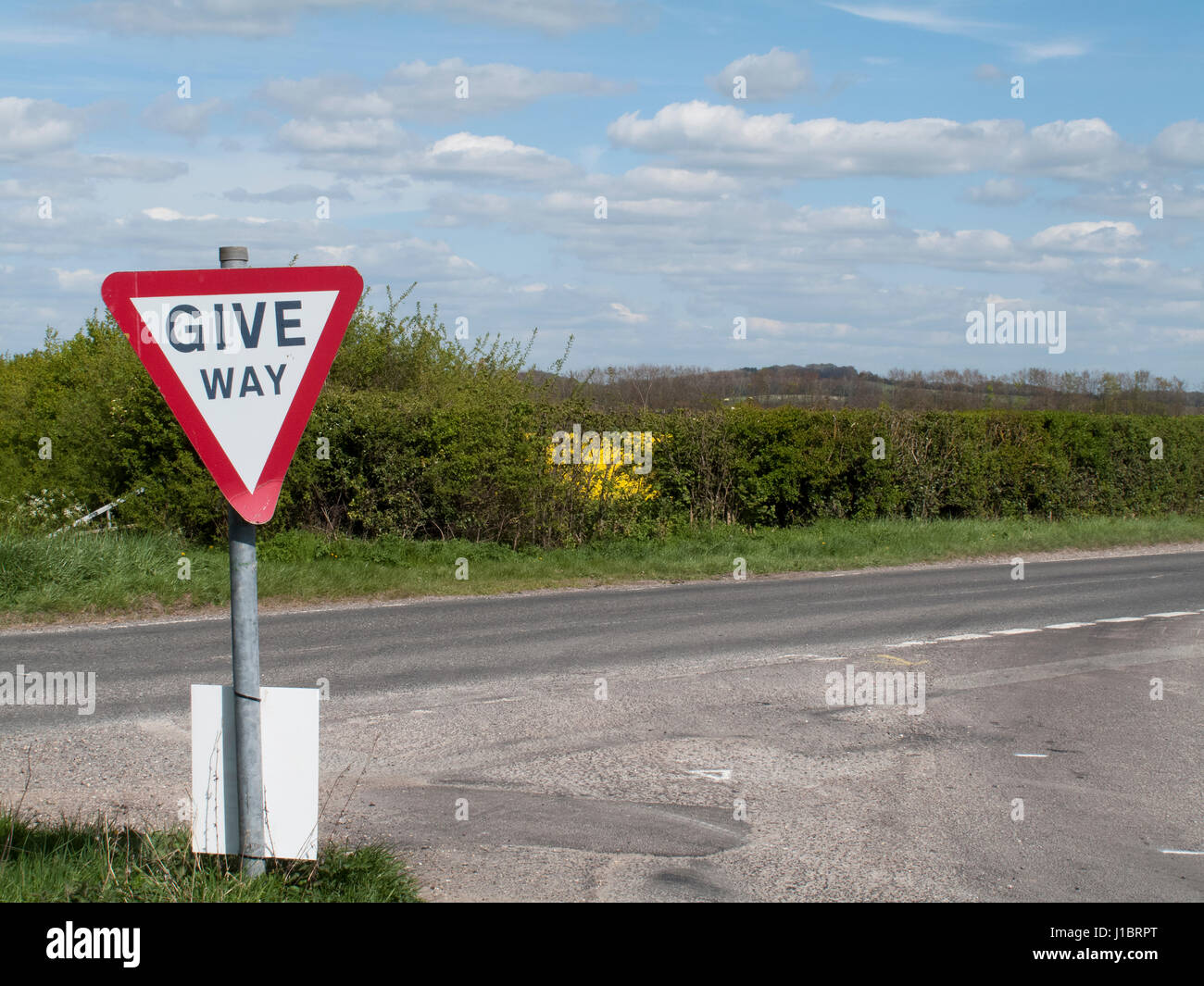 West Tytherley, Hampshire, Inghilterra - Aprile 18, 2017: dare modo segno di traffico sulla giunzione a T di una singola corsia paese via con la strada principale Foto Stock