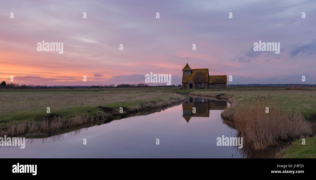 Fairfield Church, Romney Marsh, Kent, Inghilterra al tramonto con la chiesa riflessa in una diga vicina. Foto Stock