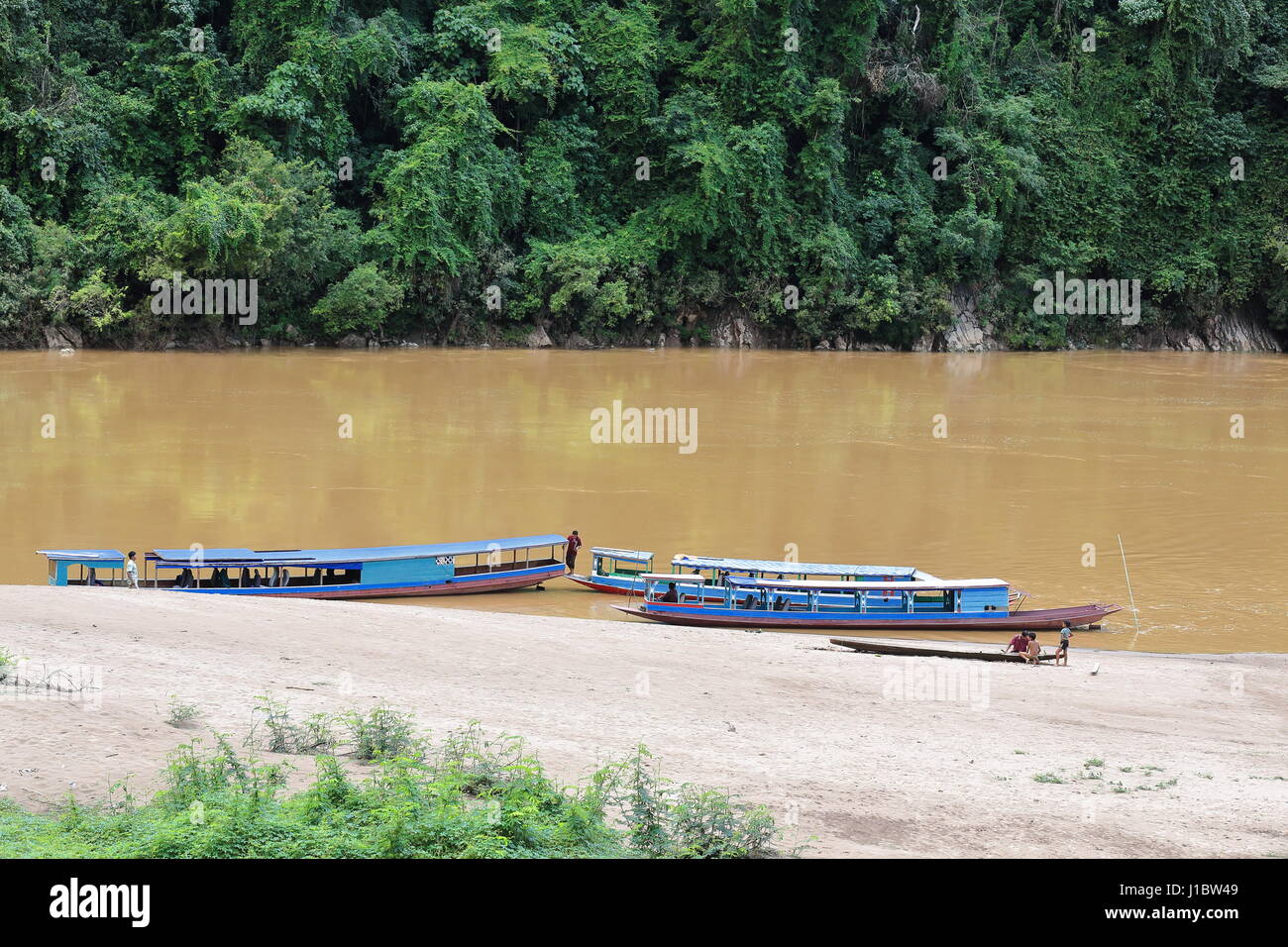 Nam Ou river, Laos-October 9, 2015: slowboats locali percorrono il fiume che serve come principale mezzo di trasporto in mancanza di terra di strade. Le imbarcazioni turistiche stra Foto Stock