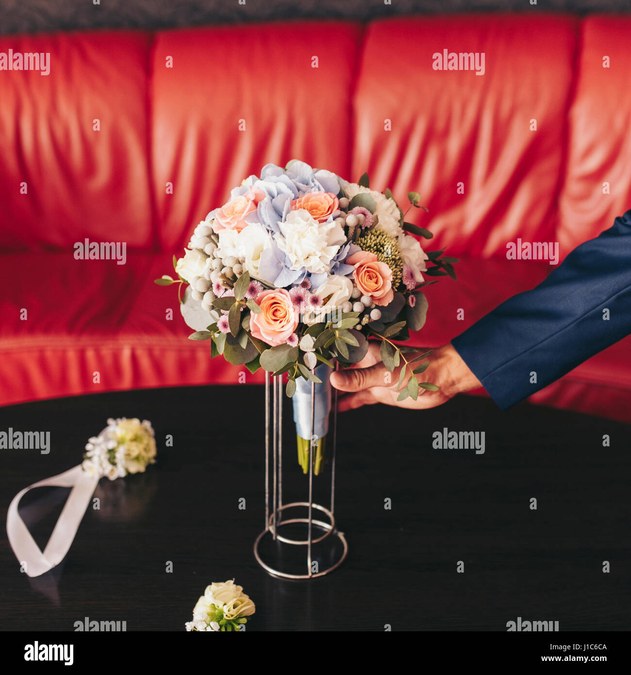 Uomo caucasico immissione bouquet di fiori sul tavolo Foto Stock