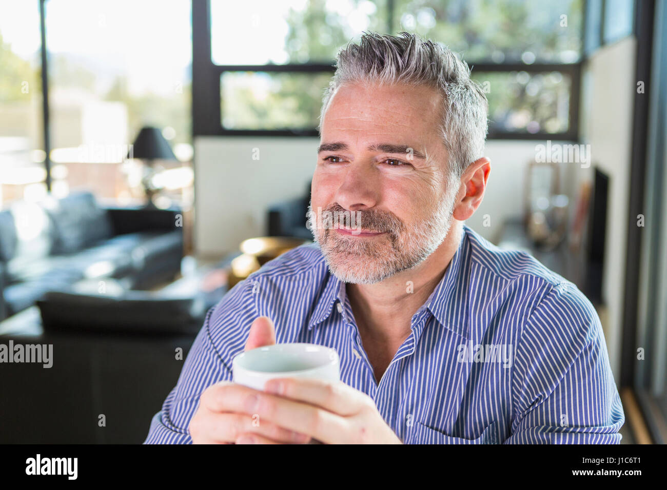 Uomo caucasico di bere il caffè e fantasticando Foto Stock