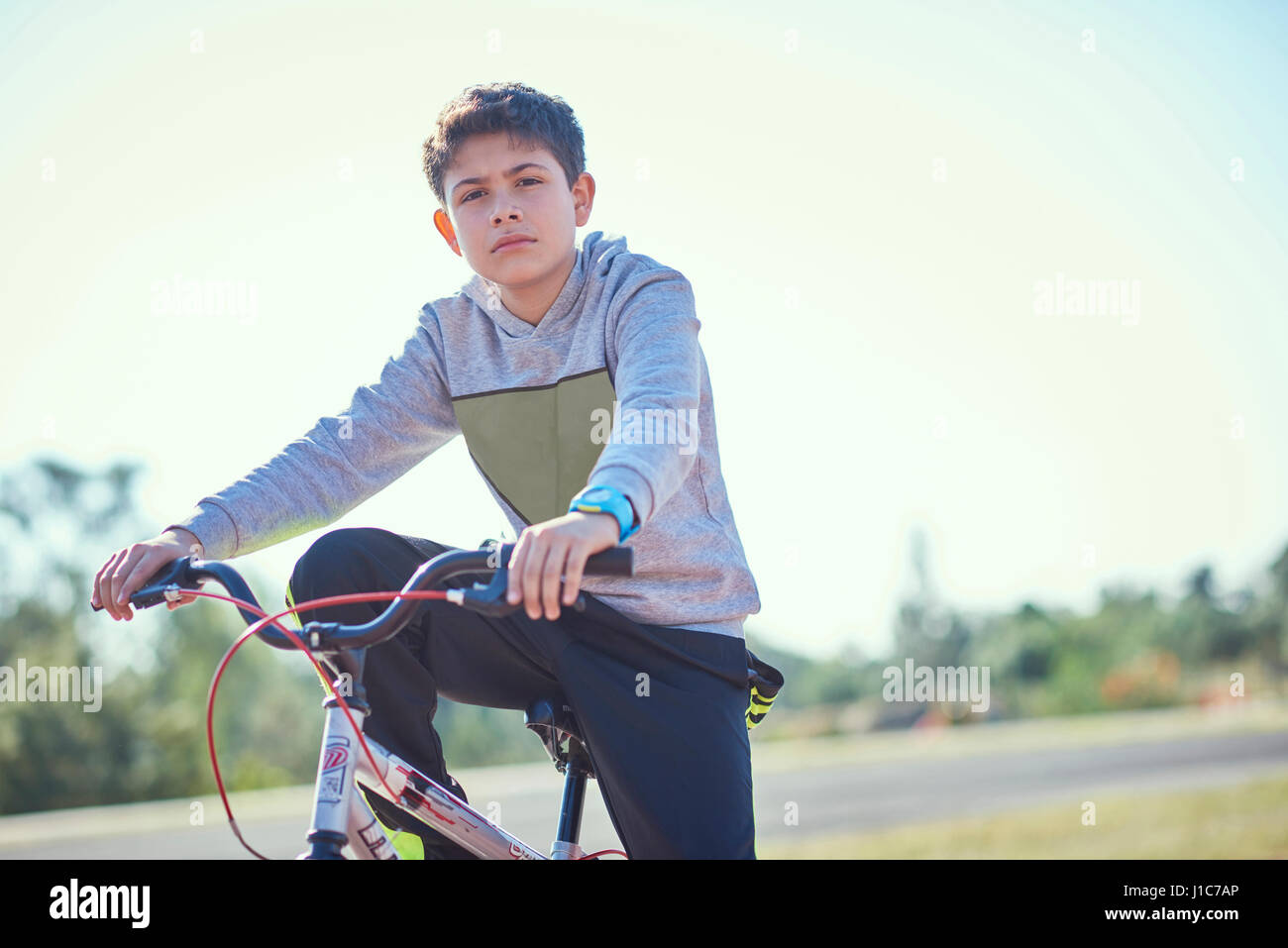 Grave ragazzo ispanico che pongono in bicicletta Foto Stock