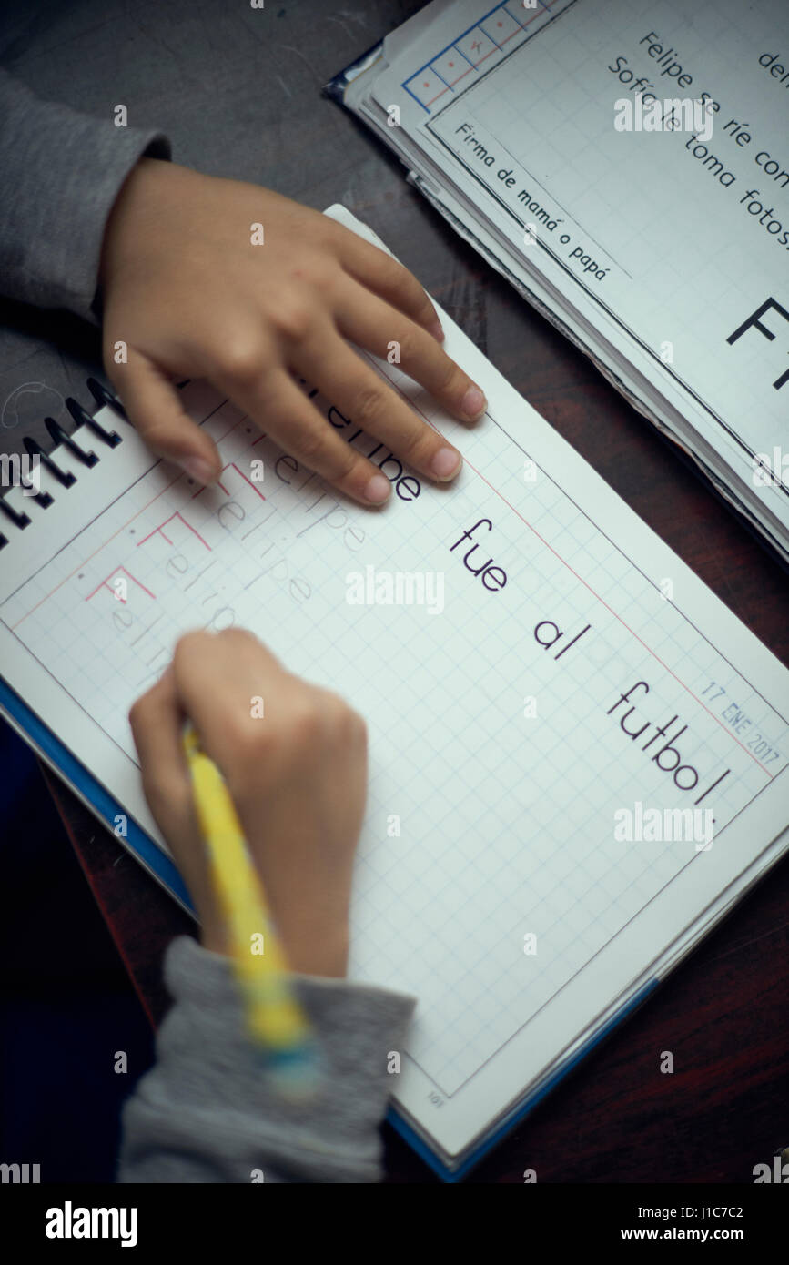 Ragazzo ispanico praticanti alfabeto di scrittura Foto Stock