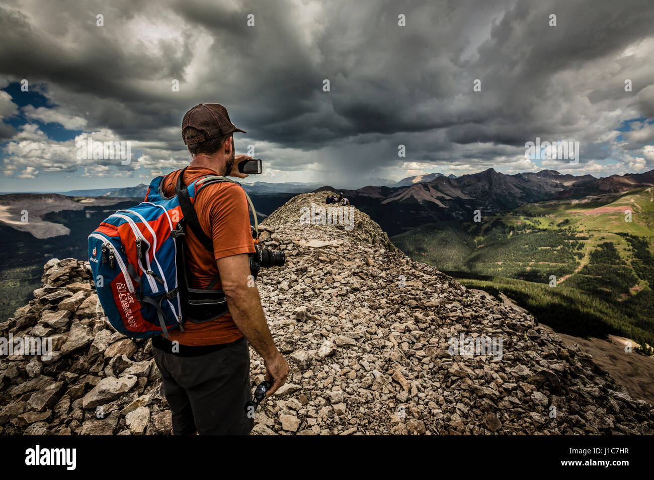 Eric Odenthal di scattare una foto con il suo iPhone sul vertice di ingegnere di montagna, Colorado. Foto Stock