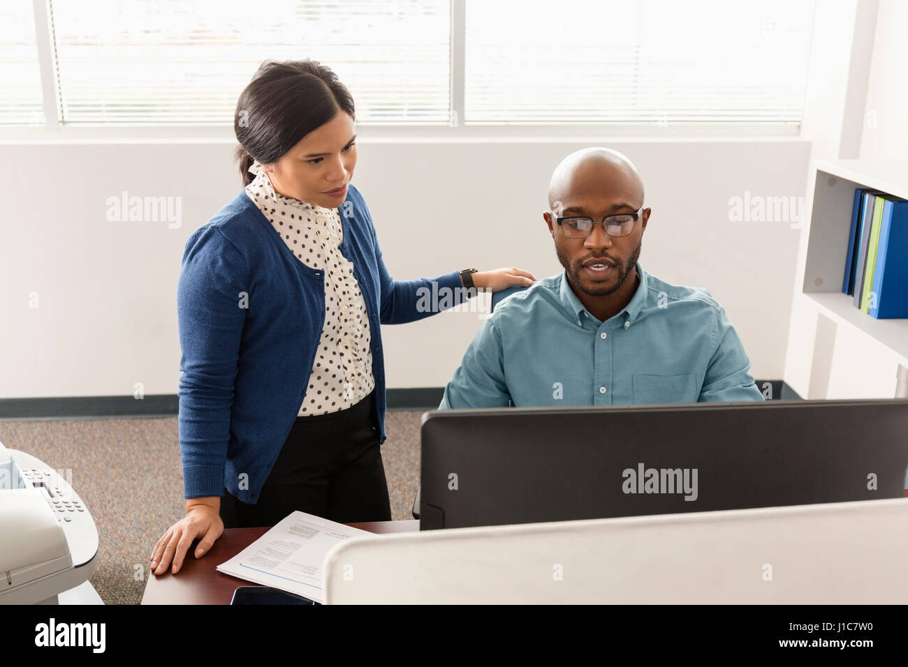 Uomo e donna che lavorano al computer in ufficio Foto Stock
