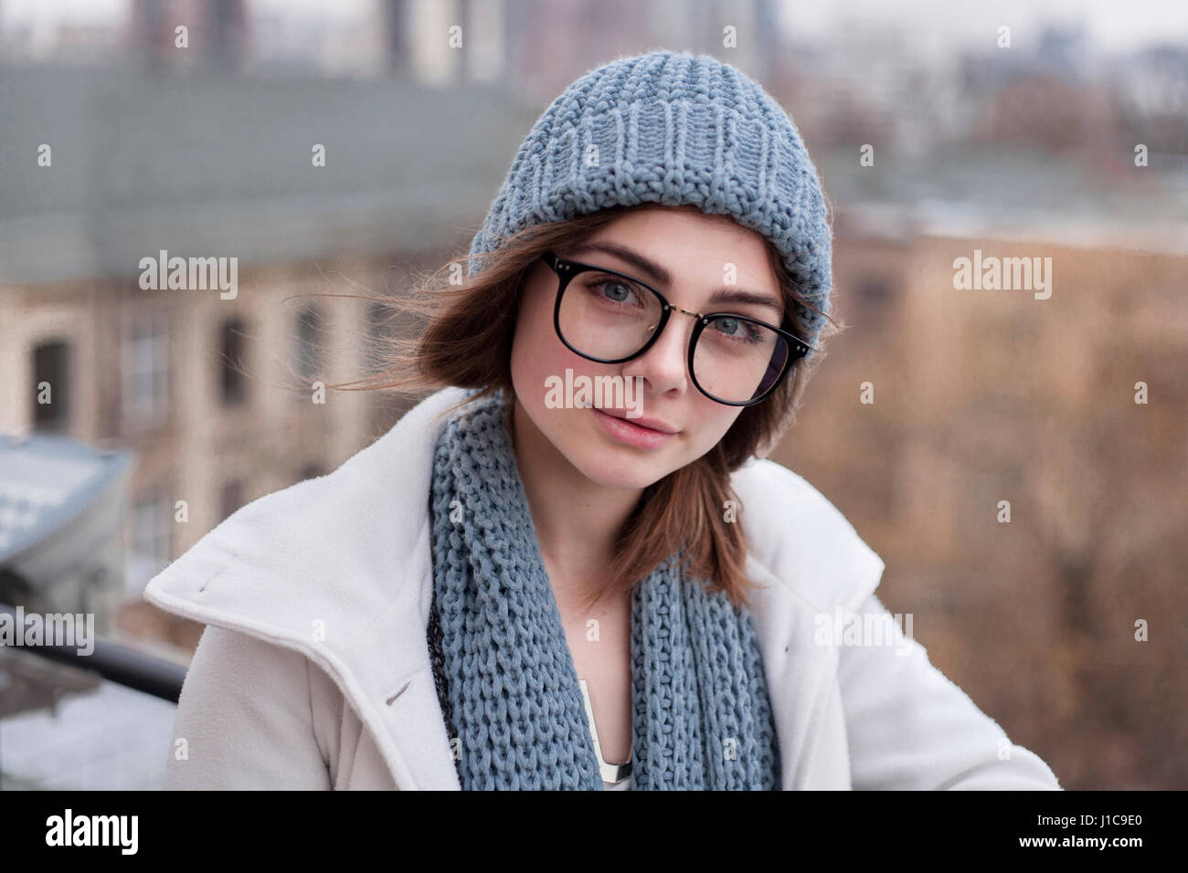 La donna caucasica indossando occhiali con sciarpa e cappello Foto Stock