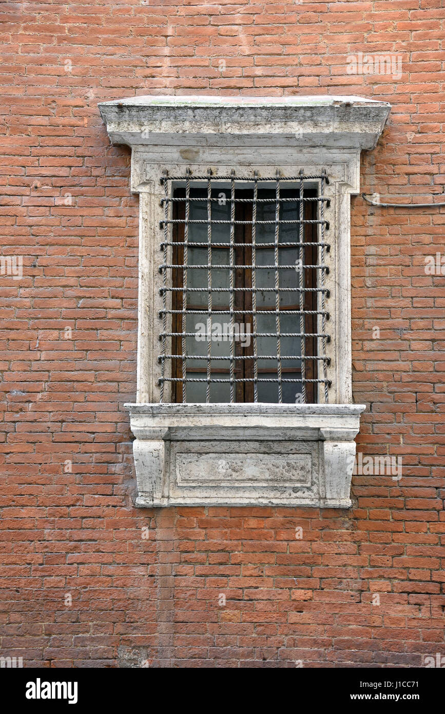 Vecchia finestra con decorazioni in marmo sulla parete di mattoni Foto Stock