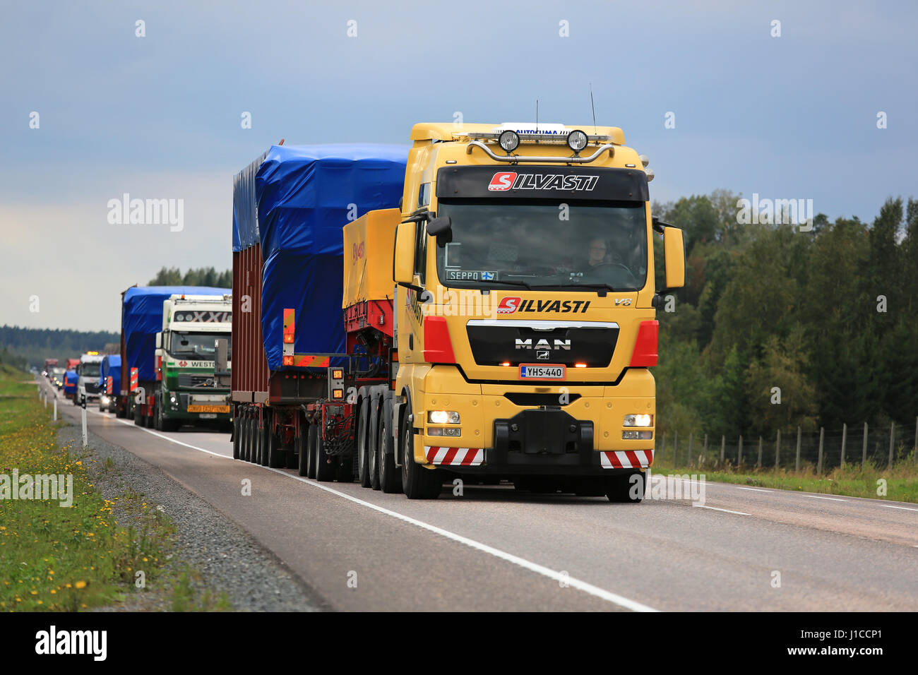 ORIVESI, Finlandia - 1 Settembre 2016: Giallo MAN V8 semi carrello cale ampia carico nel convoglio di quattro eccezionali per i trasporti stradali di oggetti industriali. Foto Stock