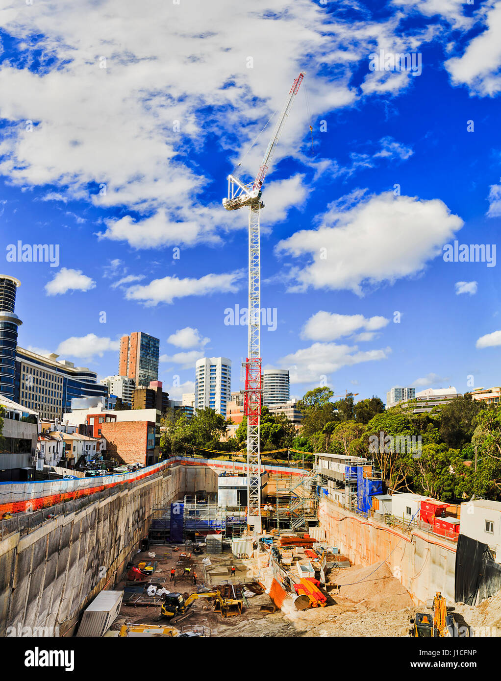 Nuovo multi-storie casa costruzione sito dalla fossa profonda di alta costruzione di gru su una soleggiata giornata estiva in densly sviluppato occupato sobborgo di Sydney. Foto Stock