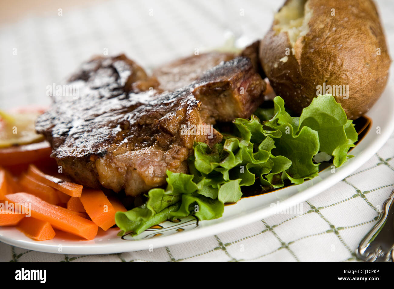 Una succosa bistecca alla fiorentina con patate al forno e verdure Foto  stock - Alamy