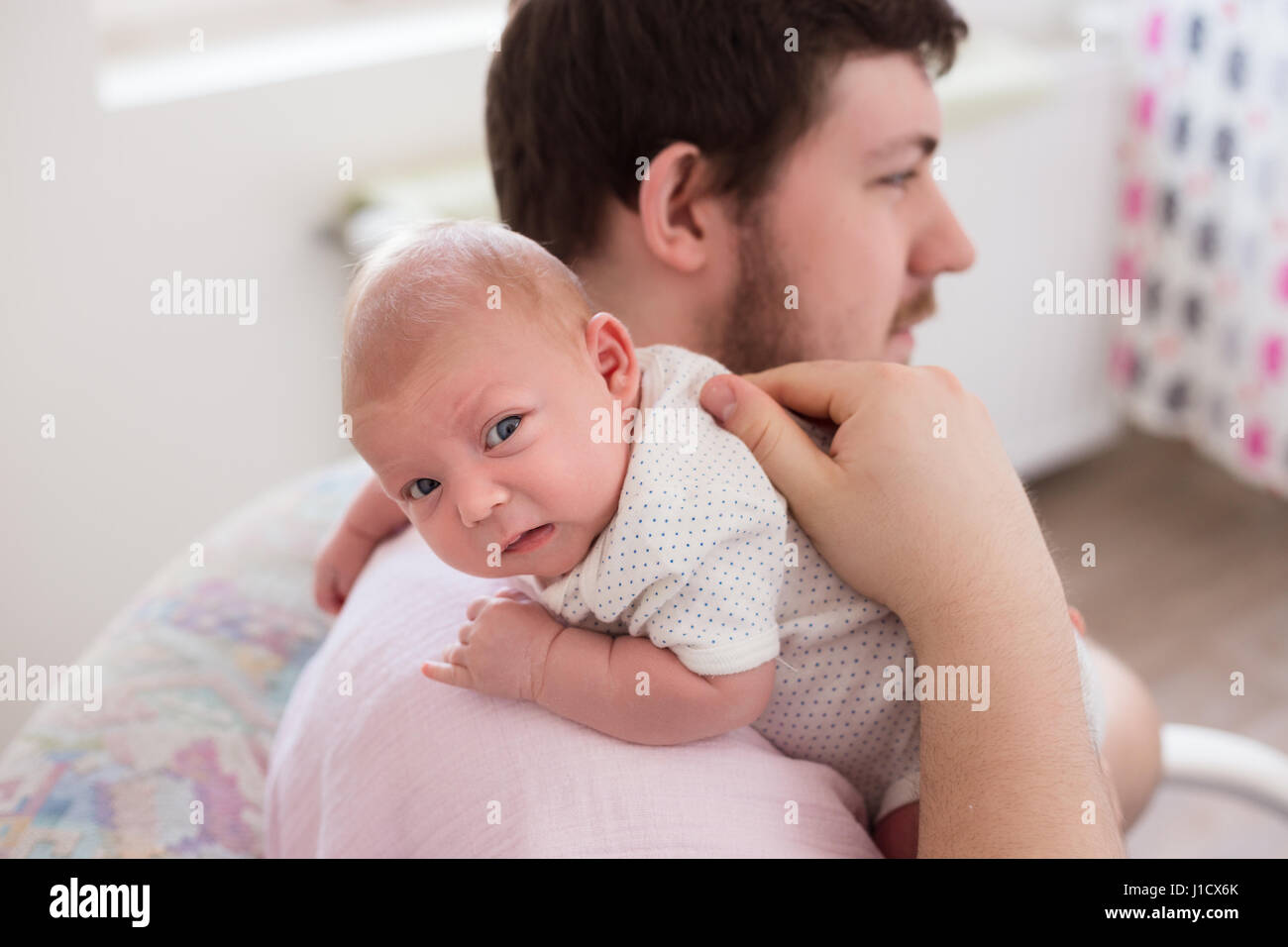 Giovane padre eruttazione il suo neonato figlia, tenendo il suo affetto. Lo stile di vita della sessione di famiglia.. Foto Stock