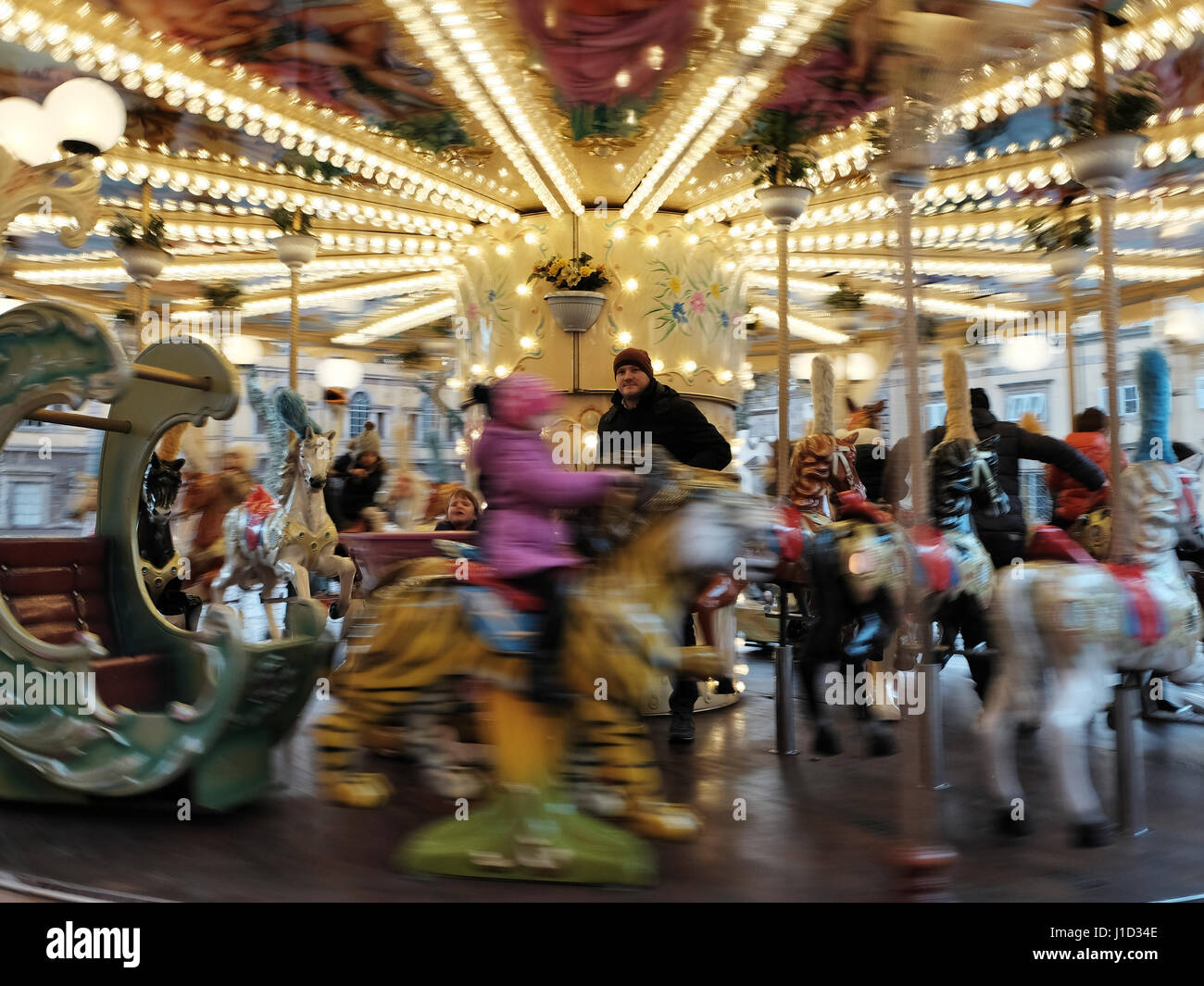Giostra di movimentazione - Carny - merry-go-round di girare intorno alla rotatoria, attendant congelata in un colorato sfondo - Lucca, Toscana, Italia, Europa Foto Stock