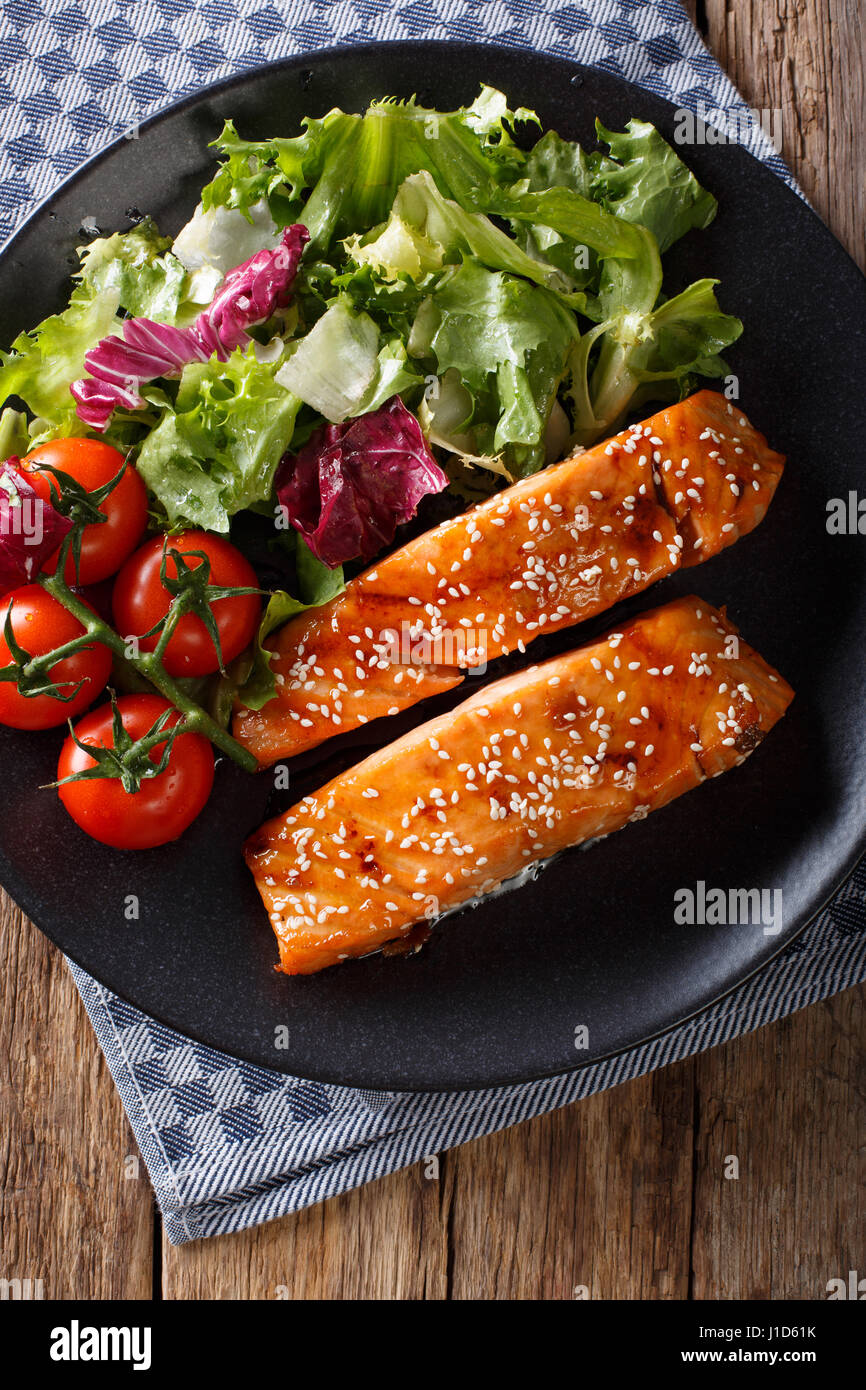 Di salmone al forno di filetto con semi di sesamo e insalata fresca closeup  su una piastra. Vista verticale da sopra Foto stock - Alamy