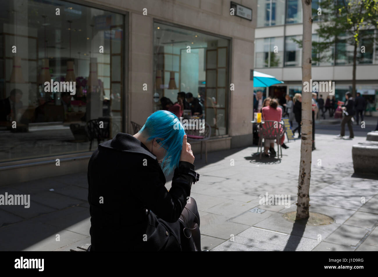 Una donna con capelli blu, il 19 aprile, nella City di Londra, Inghilterra. Foto Stock