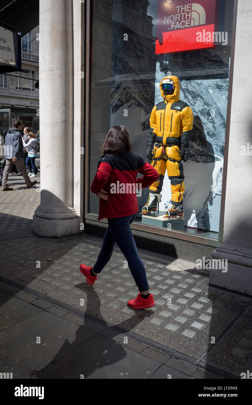 Un passante a piedi passato completamente attrezzata-out manichino di un alpinista nella finestra di attrezzature esterne rivenditore Nord faccia su Regent Street, Foto Stock