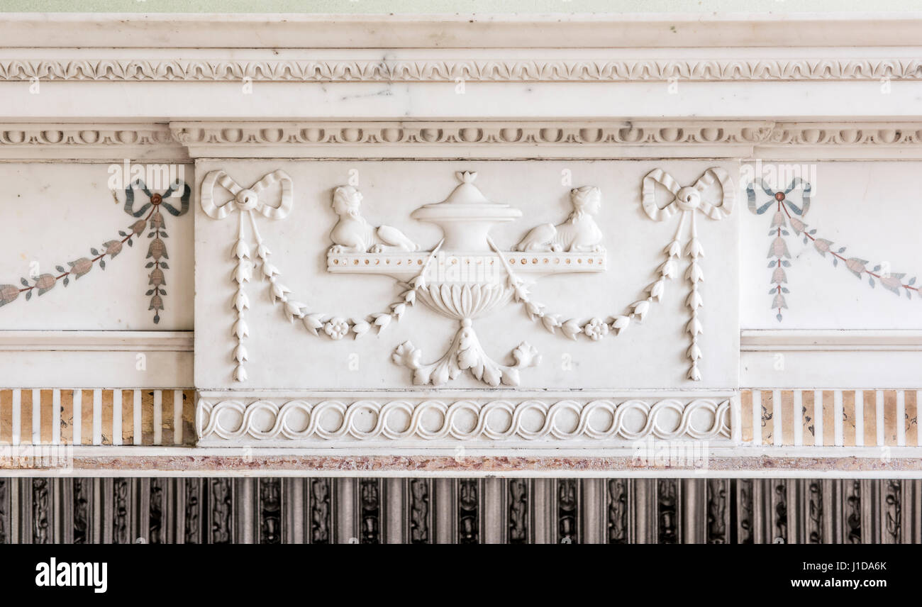Ornate sculture su marmo bianco camino in pietra circondano e mantello Foto Stock
