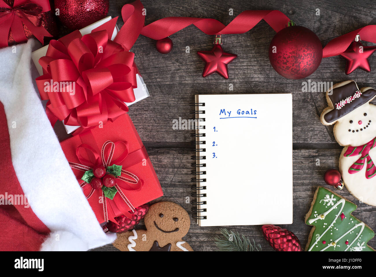 Sfondo di natale con decorazione nastro rosso di prua e di ornamento con la scrittura il mio obiettivo in aprire il notebook sul tavolo di legno vista superiore, impostazione obiettivo conc Foto Stock