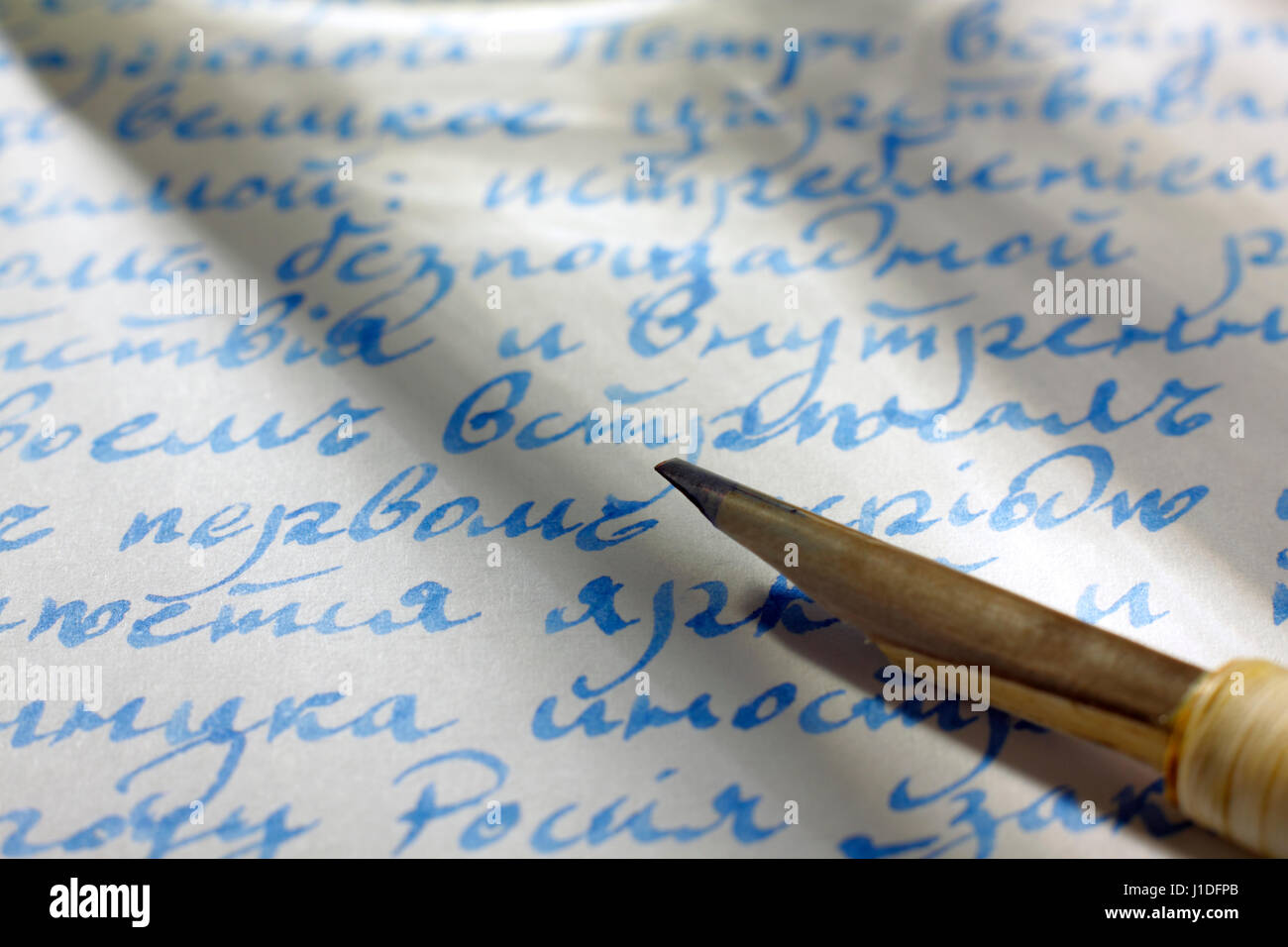 Il testo scritto a mano in alfabeto cirillico (lingua russa, vecchio scritto prima di 1918) su carta con inchiostro blu e il cappello a punta di penna Foto Stock