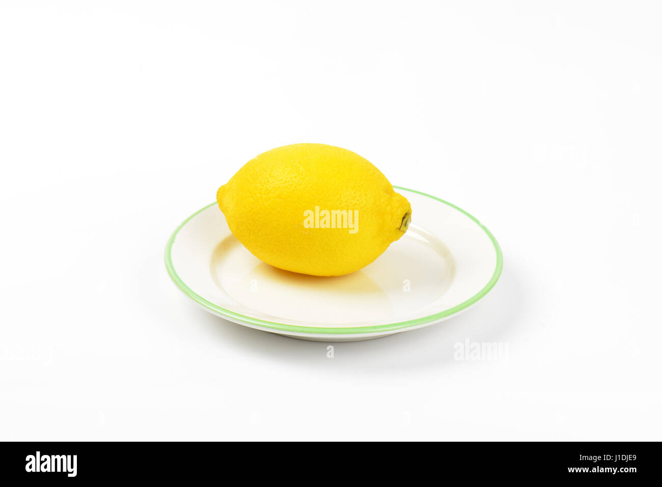 Limone maturo su una piastra bianca Foto Stock