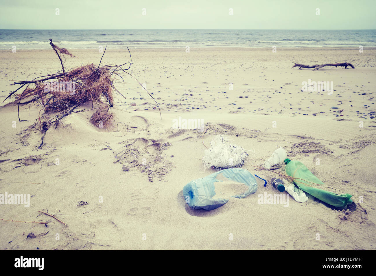 Vintage foto dai toni di immondizia a sinistra su una spiaggia, inquinamento ambientale concetto foto, messa a fuoco selettiva. Foto Stock