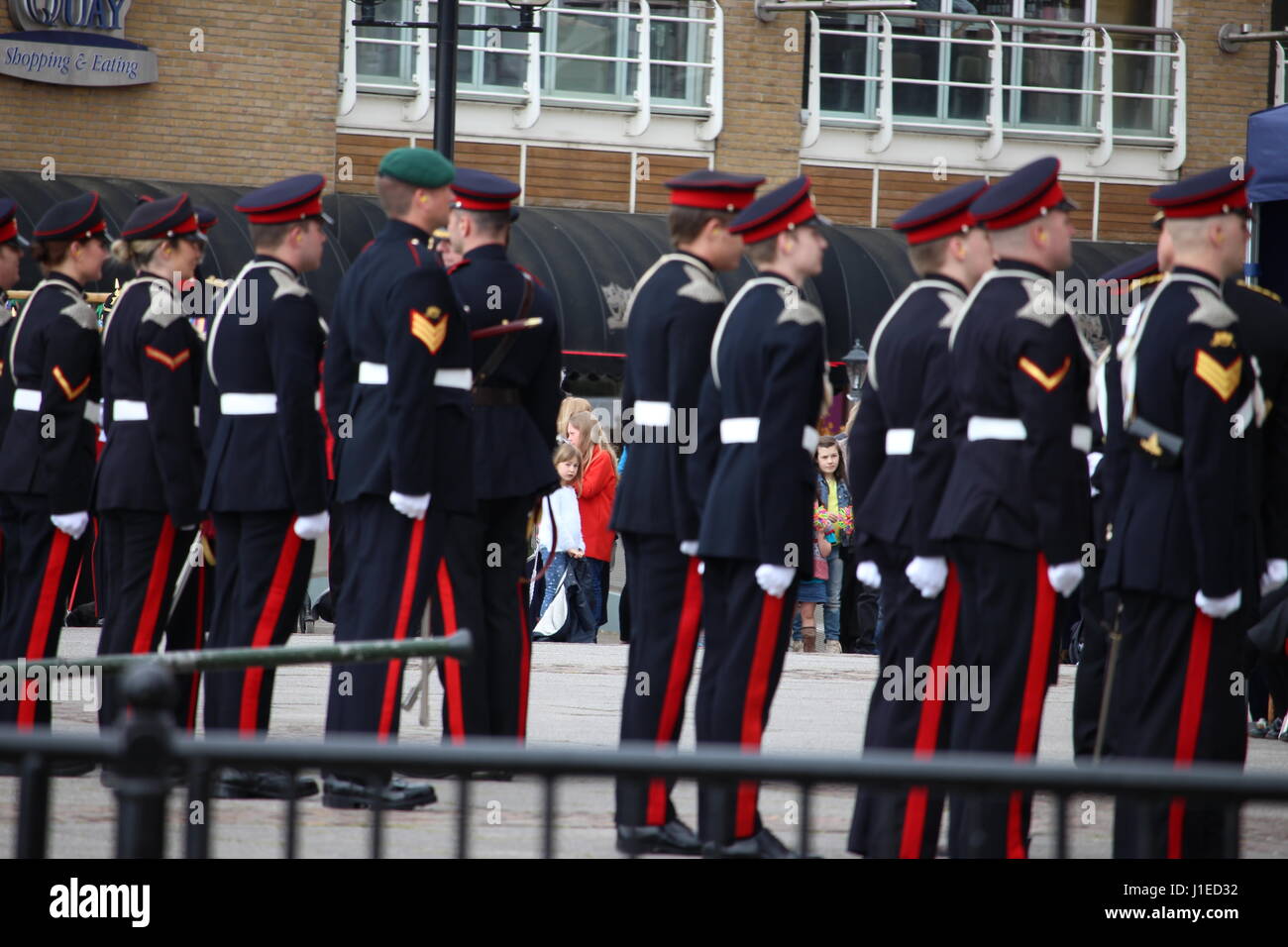 Bambini piccoli guardare dalla folla durante i preparativi per un 21-gun salutate in onore di Sua Maestà la Regina Elisabetta II per il compleanno, al di fuori della National Assembly for Wales, la Baia di Cardiff, Galles, UK. 21 Aprile 2017 Foto Stock