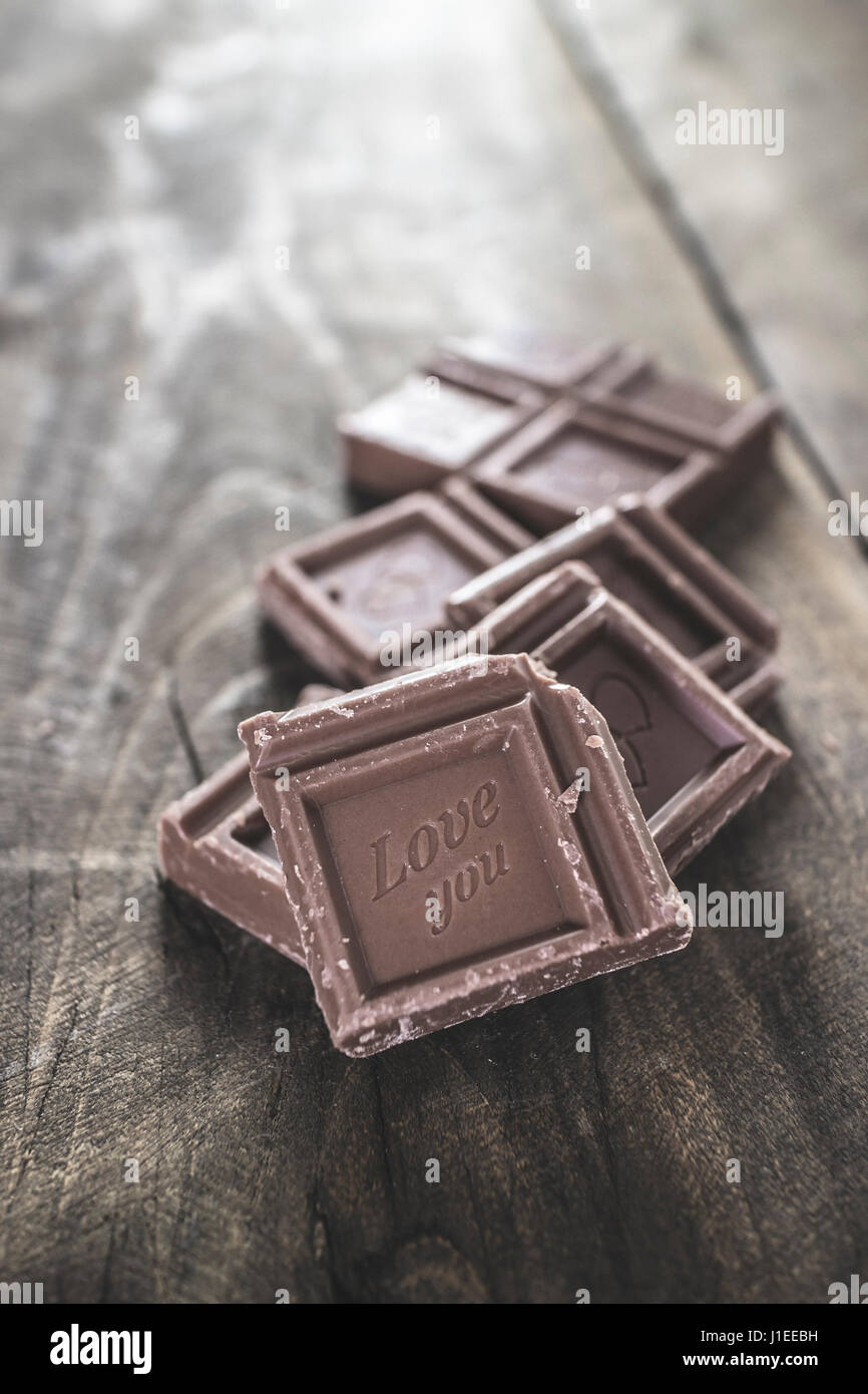 Pezzi di cioccolato su sfondo di legno, close up Foto Stock