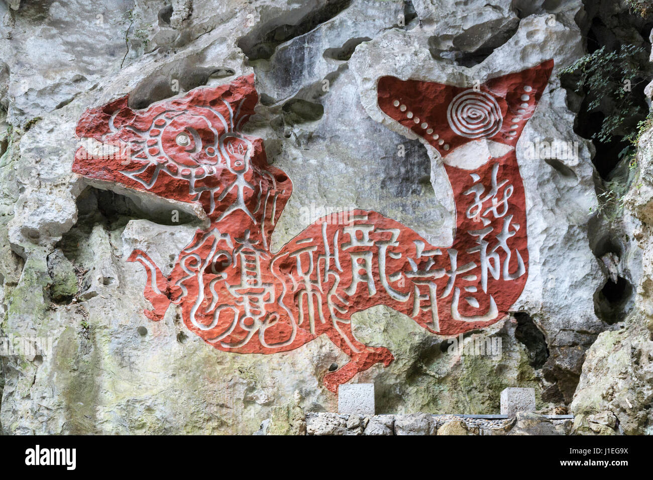 Cina, Guizhou, Dragon Palace Scenic Area. Dragon scolpite sulla scogliera con la calligrafia l'iscrizione. Foto Stock