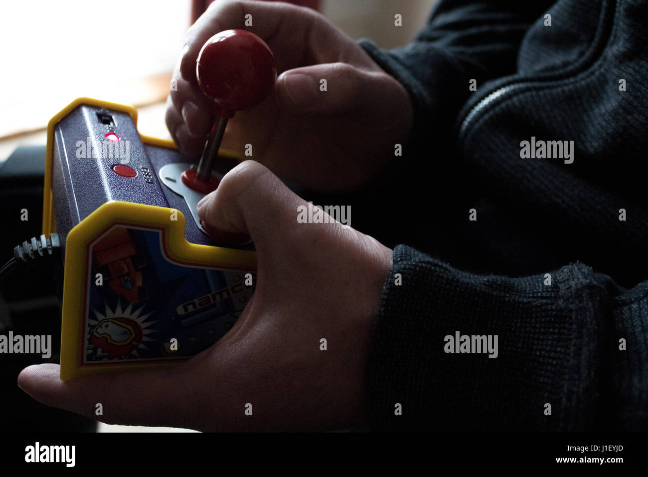 Adulto tanga millenario gamer gioca vintage plug and play mini gioco arcade retrò con centralina del joystick Foto Stock
