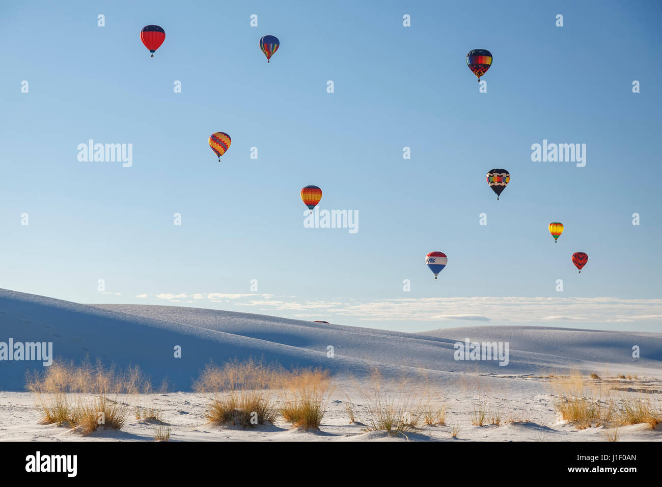 I palloni ad aria calda oltre le dune di sabbia ed erbe, White Sands Balloon Festival, White Sands National Park, Alamogordo, Nuovo Messico USA Foto Stock