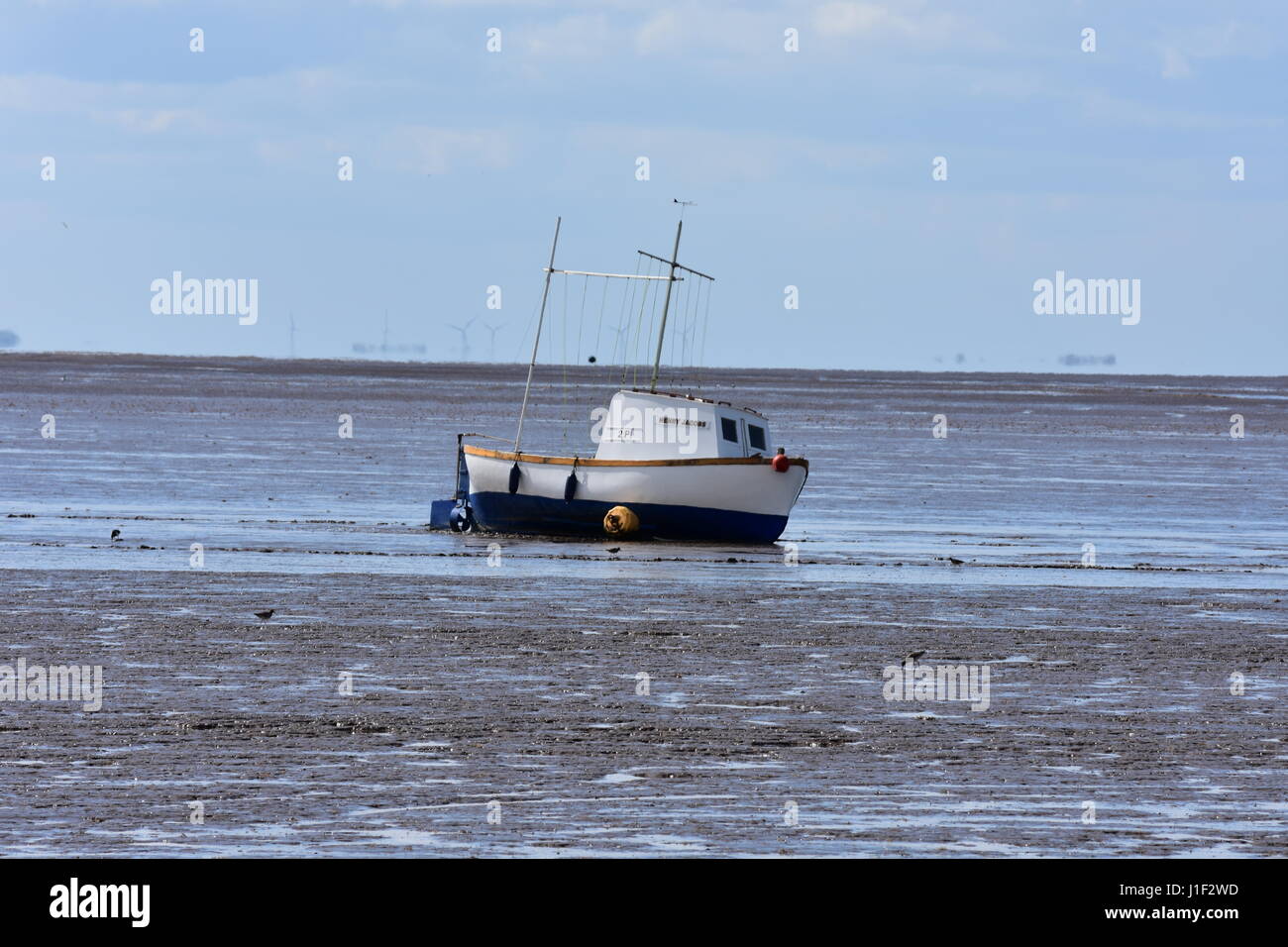 Barca bloccati su una banca di fango sulla spiaggia Snettisham a bassa marea, Snettisham, Norfolk, Regno Unito Foto Stock