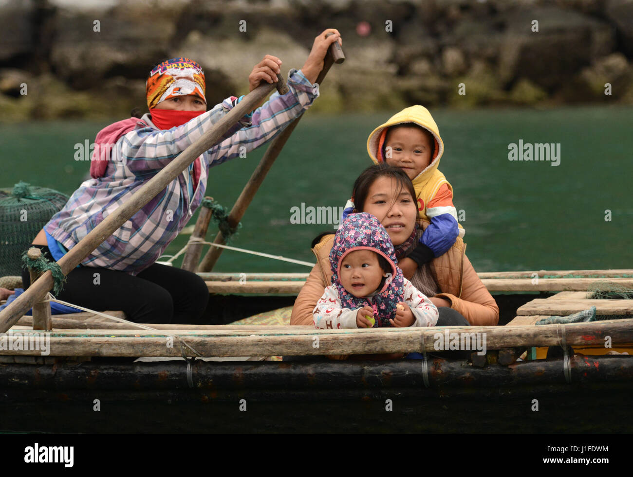 Fisherman's famiglie nella baia di Halong contribuire al reddito familiare con la vendita di spuntini e negozio di souvenir al passaggio di imbarcazioni turistiche. Foto Stock